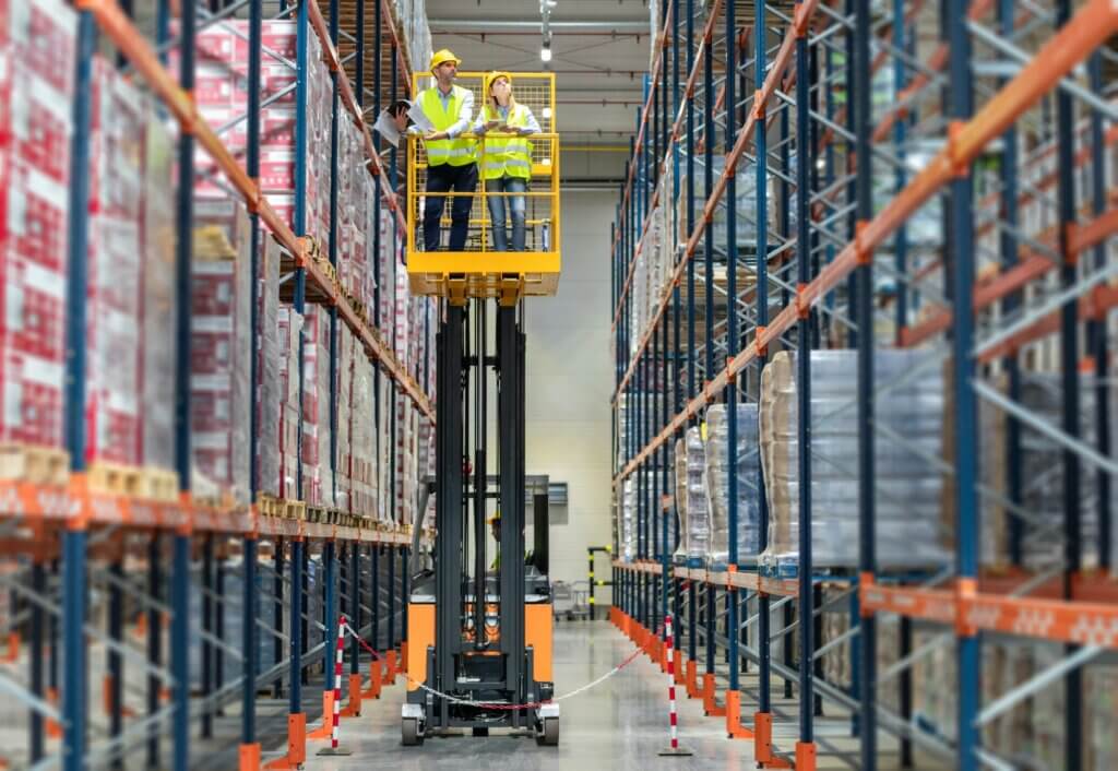Warehouse workers on the height using lift work platform to check inventory